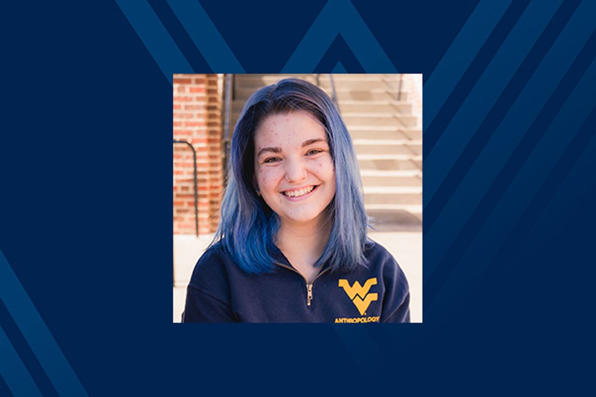 smiling young woman in flying WV shirt on blue background