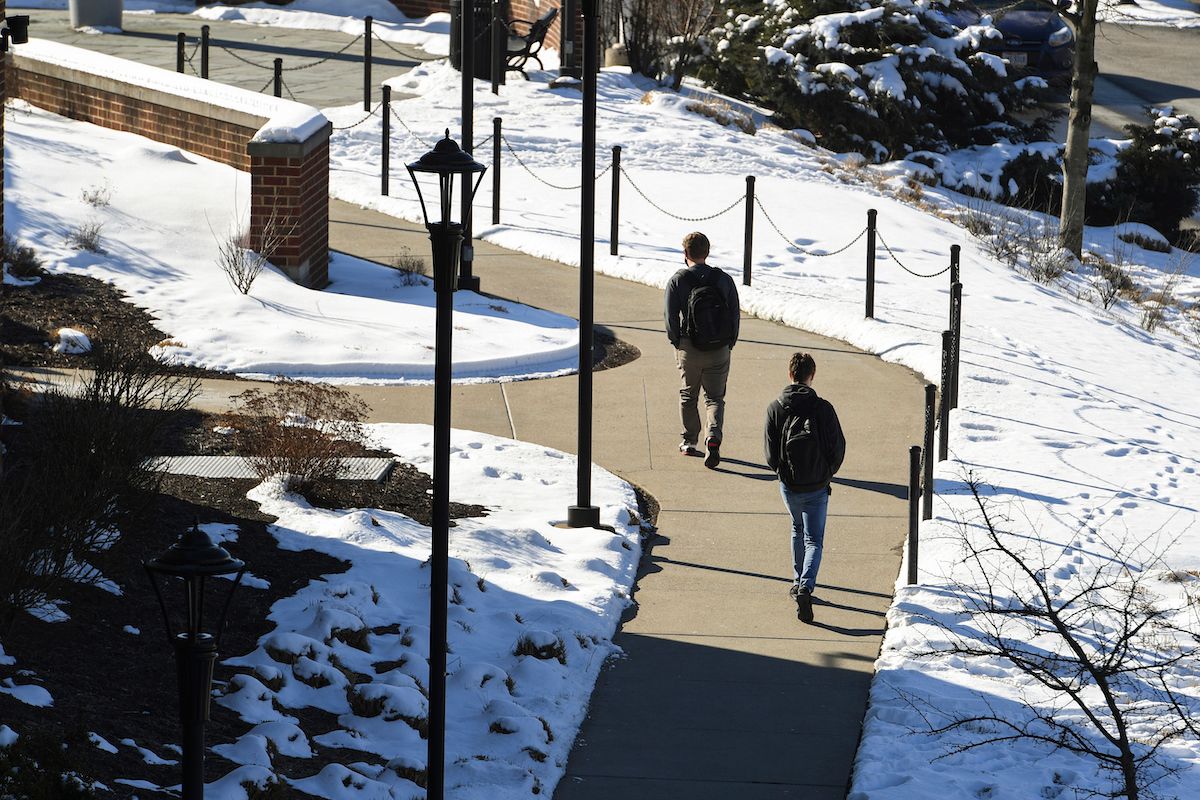 students walk through a snow covered campus in winter
