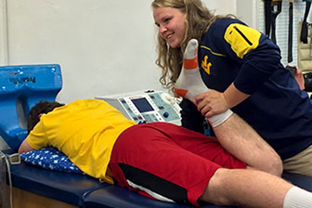 A patient being stretched out by a personal trainer.