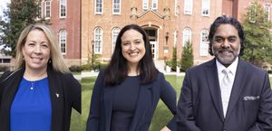 Picture of three new assistant deans at WVU. Jessica Deshler is on the left wearing a blue blue blouse and black jacket. She has long blond hair. Andrea Bebell is in the middle wearing a dark top with dark hair, and John Navaratnam is on the right.  