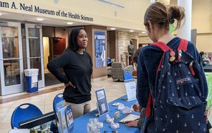 Two students standing at table at nursing fair