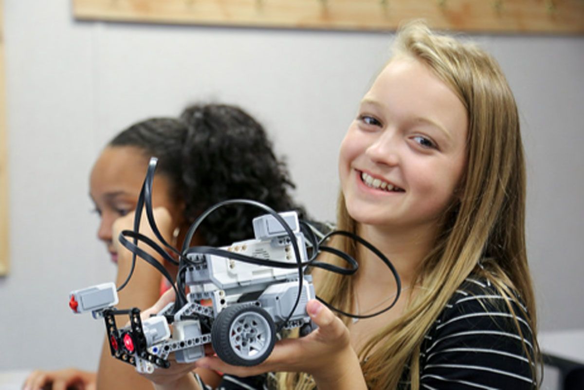A young girl holding a robot.